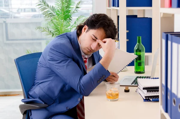 Jovem empresário empregado bebendo no escritório — Fotografia de Stock