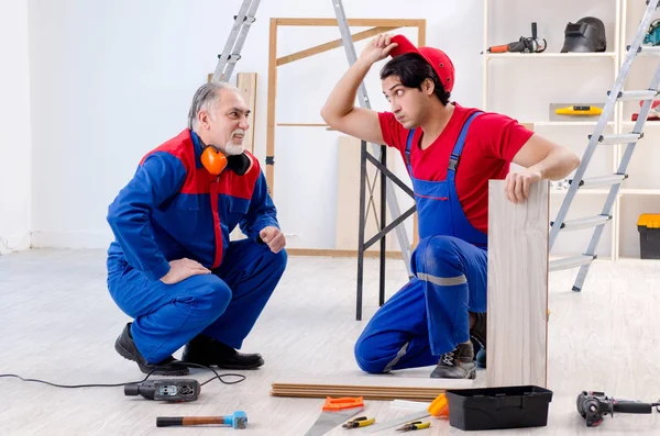 Два професійних підрядники укладання підлогового покриття вдома — стокове фото