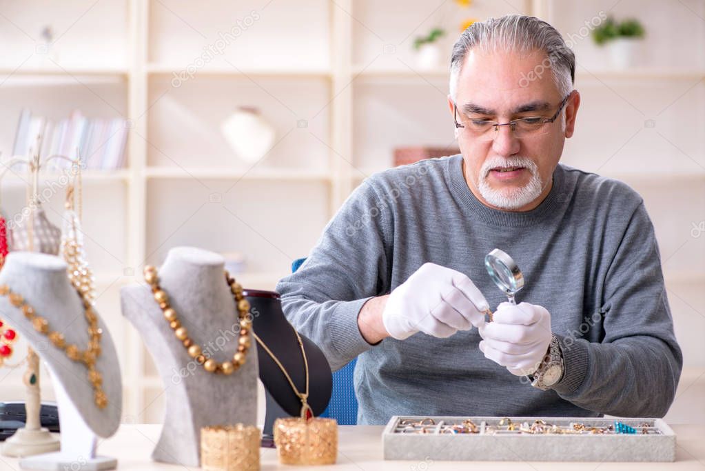 White bearded old jeweler at workshop 