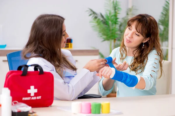 Female doctor traumatologist bandaging female patient — Stock Photo, Image