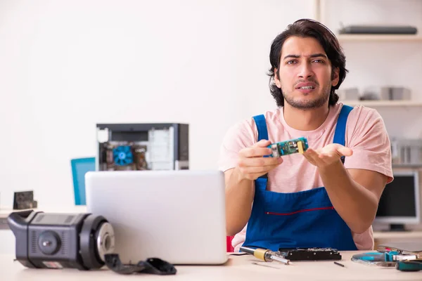 Jovem empreiteiro do sexo masculino reparando computador — Fotografia de Stock