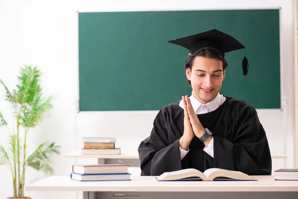 Estudante graduado na frente do quadro verde — Fotografia de Stock