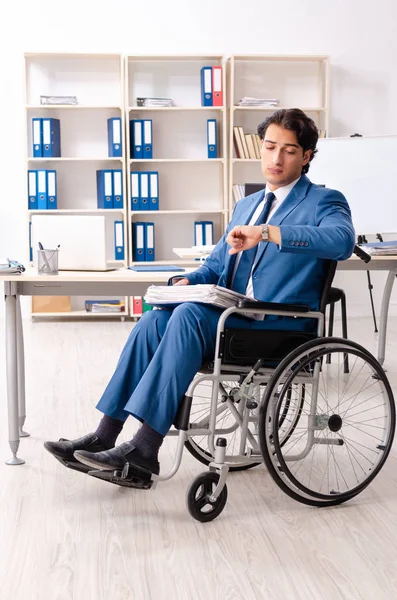 Male employee in wheelchair working at the office