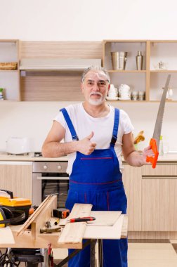 Mutfakta çalışan yaşlı bir tamirci. 