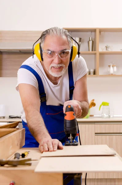 Mutfakta çalışan yaşlı bir tamirci. — Stok fotoğraf