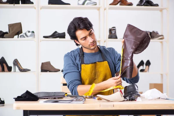 Jongeman herstellen van schoenen in werkplaats — Stockfoto