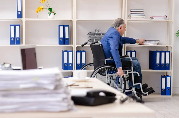 Dipendente anziano in sedia a rotelle che lavora in ufficio — Foto Stock