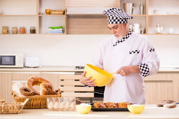 Viejo panadero trabajando en la cocina — Foto de Stock