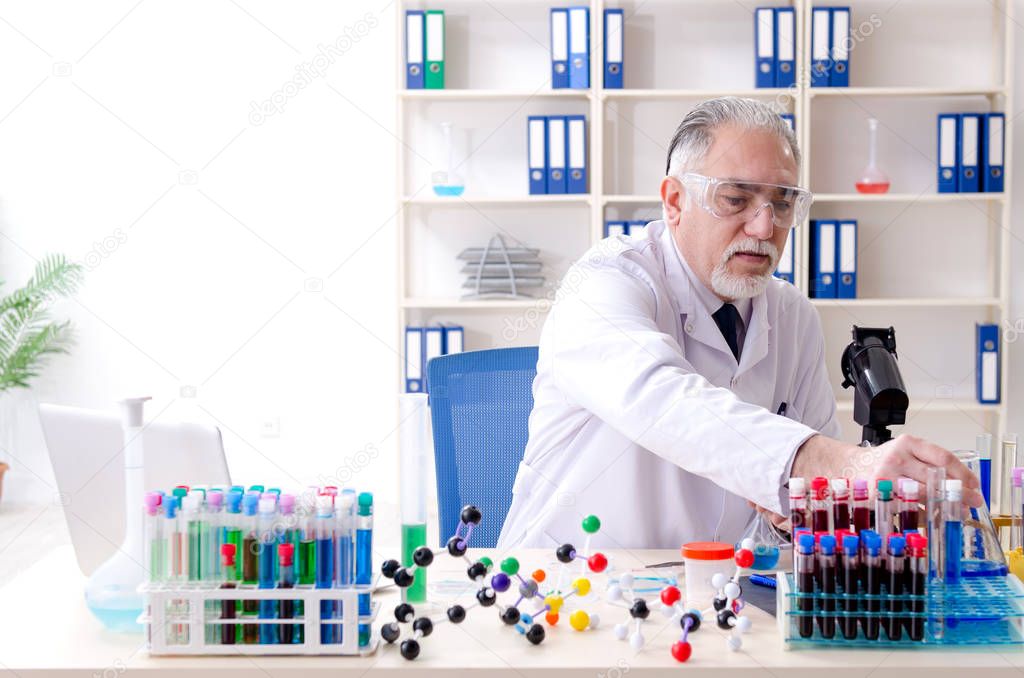 Old male chemist working in the lab 