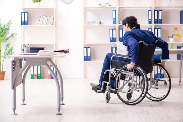 Молодий чоловік працівник в інвалідному візку працює в офісі — стокове фото