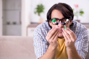 Evde sınava hazırlanan genç fizikçi öğrenci.    