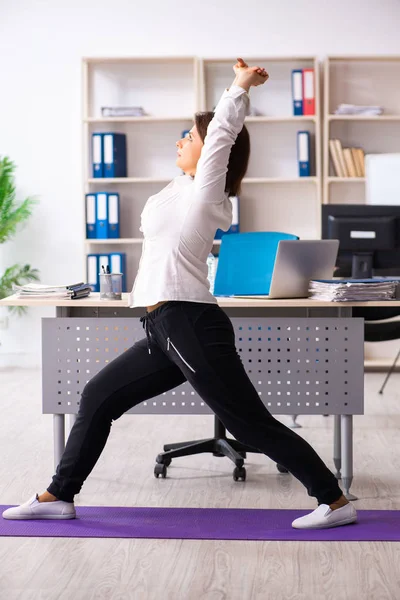 Женщина среднего возраста, выполняющая упражнения в офисе — стоковое фото