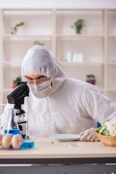 Wetenschapper in lab over GGO-groenten en -fruit — Stockfoto