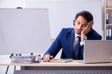 Genç yakışıklı işadamı ofiste çalışıyor.