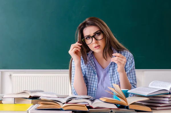 Female student in front of chalkboard — Stock Photo, Image