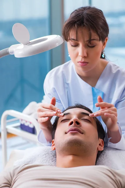 Giovane bell'uomo in visita medico cosmetologo femminile — Foto Stock