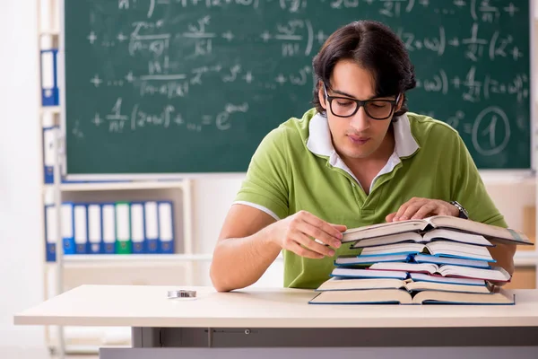 Estudiante guapo delante de pizarra con fórmulas — Foto de Stock