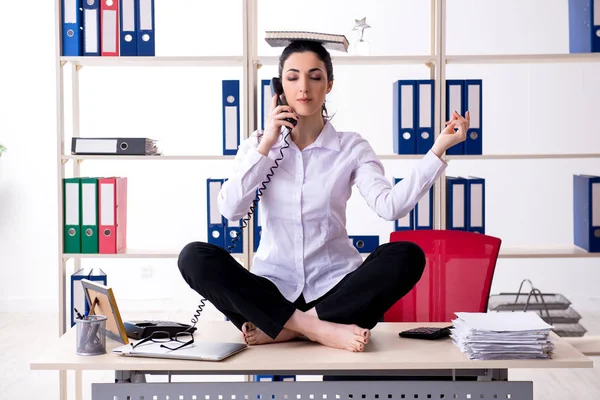 Joven empleada haciendo ejercicios en la oficina — Foto de Stock