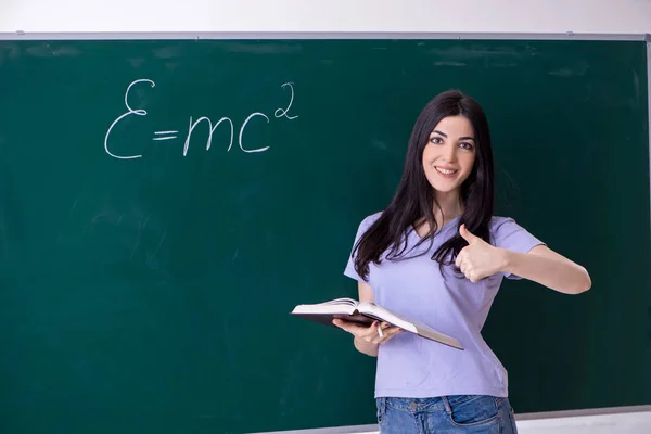 Jovem estudante professora na frente do quadro verde — Fotografia de Stock