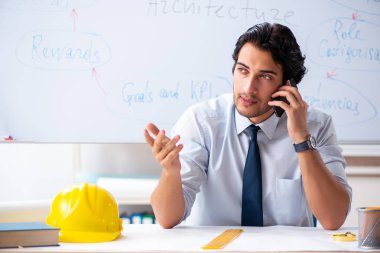 Genç erkek mimar beyaz tahtanın önünde. 