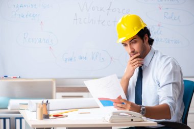 Genç erkek mimar beyaz tahtanın önünde. 