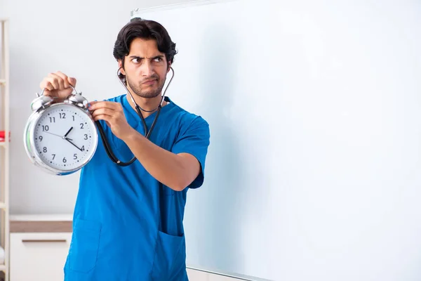 Joven médico masculino delante de la pizarra — Foto de Stock