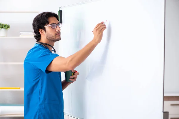 Jonge mannelijke arts voor het whiteboard — Stockfoto