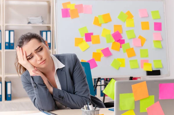 Junge Arbeitnehmerin in widersprüchlichem Prioritätenkonzept — Stockfoto