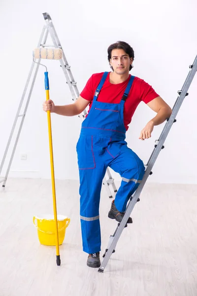 Jovem empreiteiro bonito trabalhando dentro de casa — Fotografia de Stock