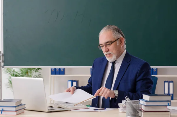 Älterer männlicher Lehrer vor Kreidetafel — Stockfoto