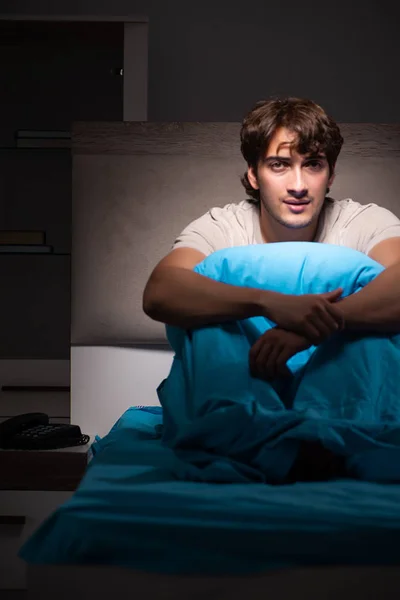 Joven hombre guapo que sufre de insomnio en la cama —  Fotos de Stock