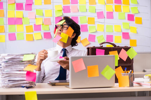 Young employee in conflicting priorities concept 