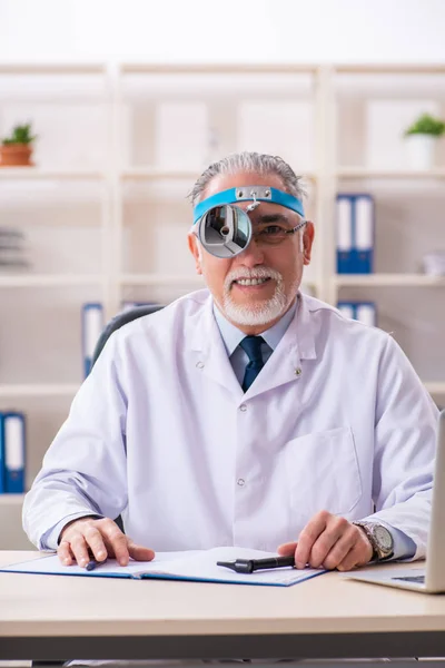 Homme âgé médecin laryngologue travaillant à la clinique — Photo