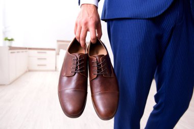 Genç yakışıklı işadamı evde ayakkabı seçimi 