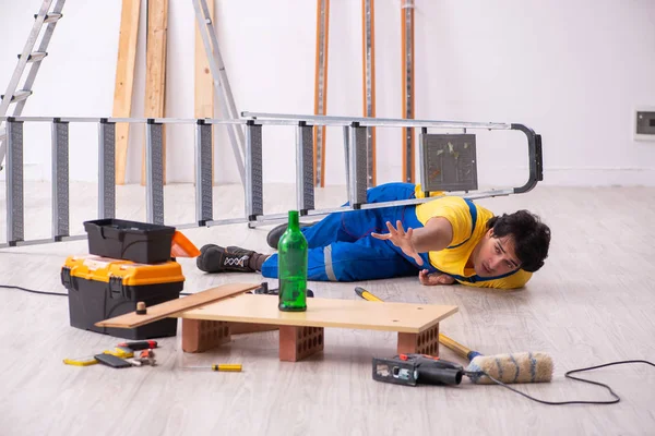 Young contractor drinking in the apartment — Stock Photo, Image