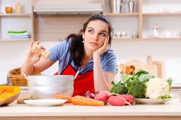 Mujer joven con verduras en la cocina — Foto de Stock