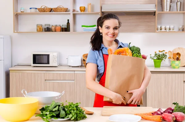 Giovane donna con verdure in cucina — Foto Stock