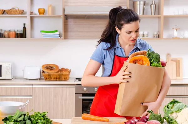 Mujer joven con verduras en la cocina —  Fotos de Stock