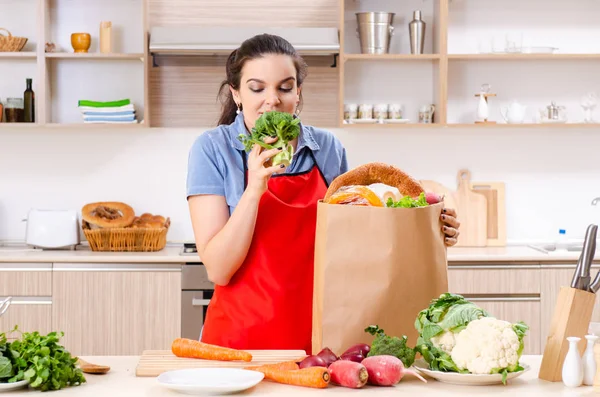 Mujer joven con verduras en la cocina — Foto de Stock