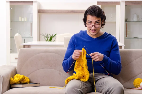 Młody przystojny mężczyzna robi na drutach w domu — Zdjęcie stockowe