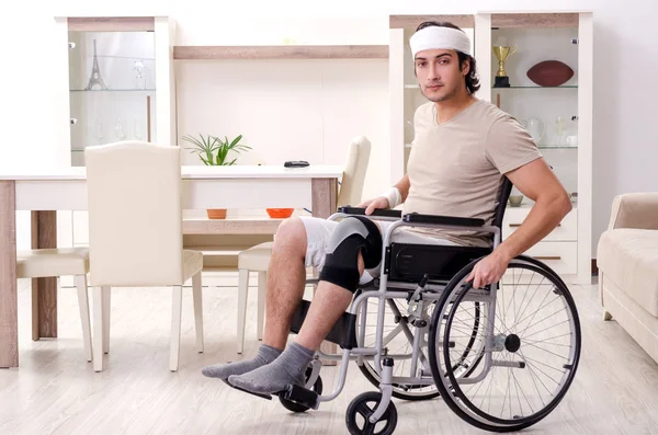 Jovem ferido fazendo exercícios em casa — Fotografia de Stock