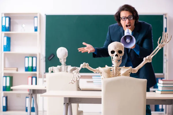 Profesor masculino y estudiante de esqueleto en el aula — Foto de Stock