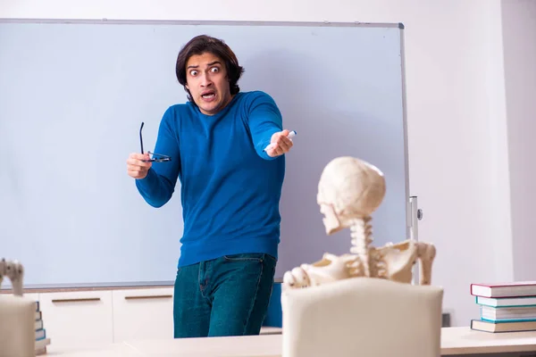 Mannelijke leraar en skelet student in de klas — Stockfoto