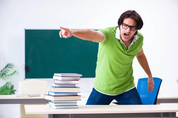 Junger männlicher Student vor grünem Brett — Stockfoto