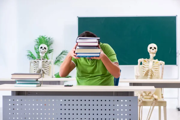Funny male student in the classroom with skeleton — Stock Photo, Image