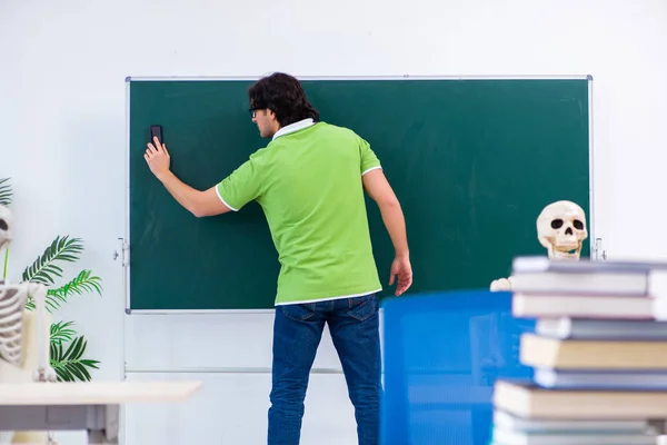 Rolig manlig student i klassrummet med skelett — Stockfoto