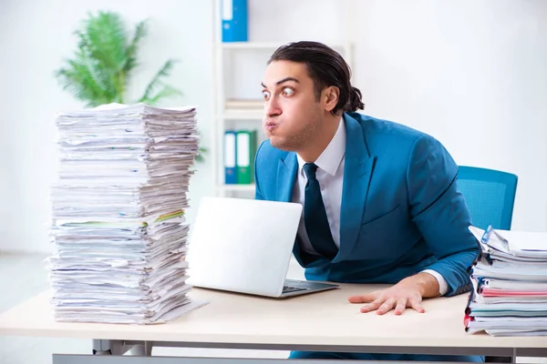 Joven empleado masculino infeliz con el trabajo excesivo — Foto de Stock