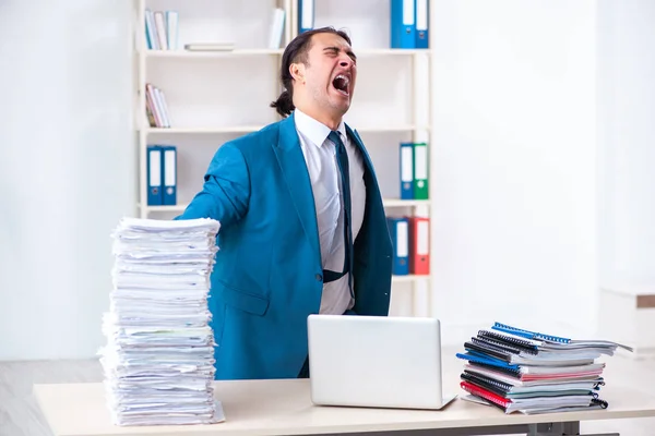 Jonge mannelijke werknemer ongelukkig met overmatig werk — Stockfoto