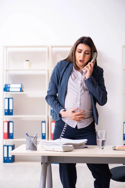 Молодая беременная женщина работает в офисе — стоковое фото
