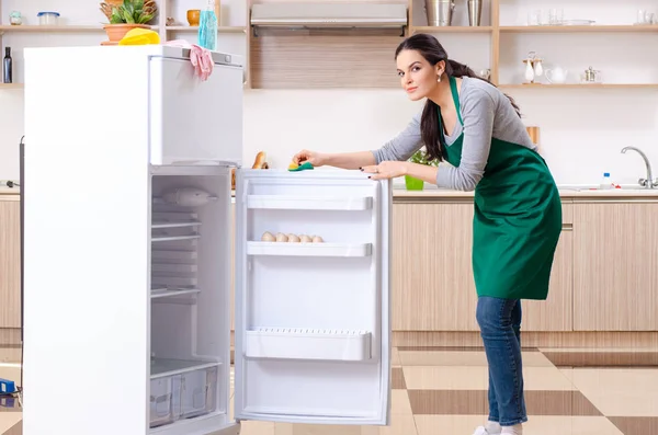 Young woman cleaning fridge in hygiene concept — Stock Photo, Image